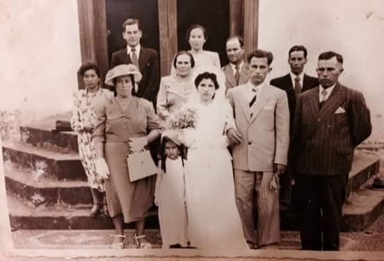 Fotografia antiga de um casamento, com a família reunida na escadaria da igreja